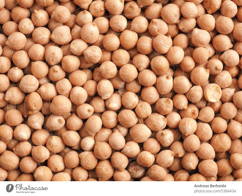 Organic dried chickpeas in a wooden bowl on a rustic wooden kitchen table organic portion harvest nourishment cereal grain pile protein uncooked vegetarian eat