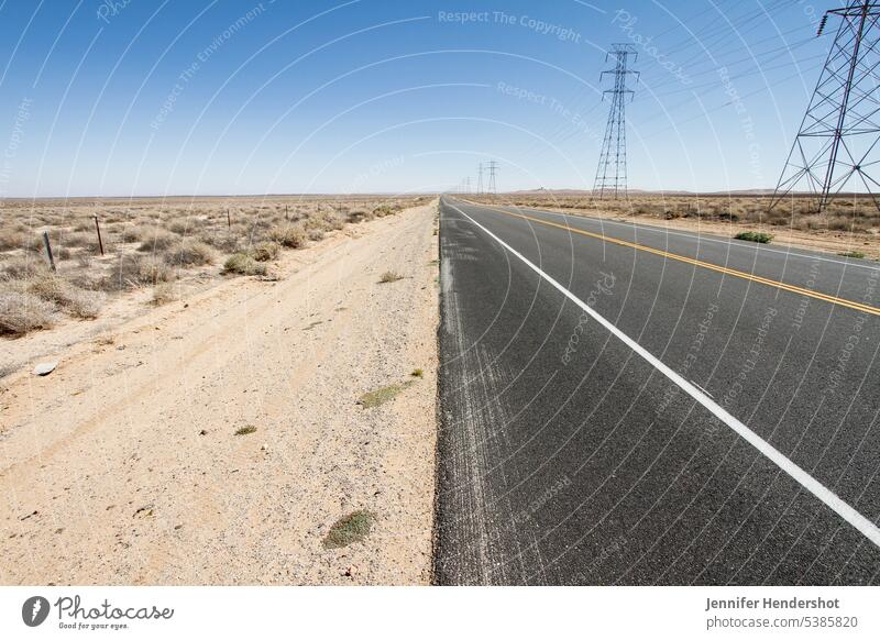 Deserted highway that disappear in the horizon, Southern California us wasteland high desert united states of america electric transmission tower utility pole