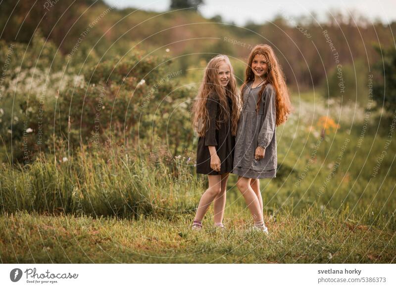 Two friends collect flowers in the field Red-haired long hair Curly Agriculture Love of nature To go for a walk sensation Contentment Sunlight