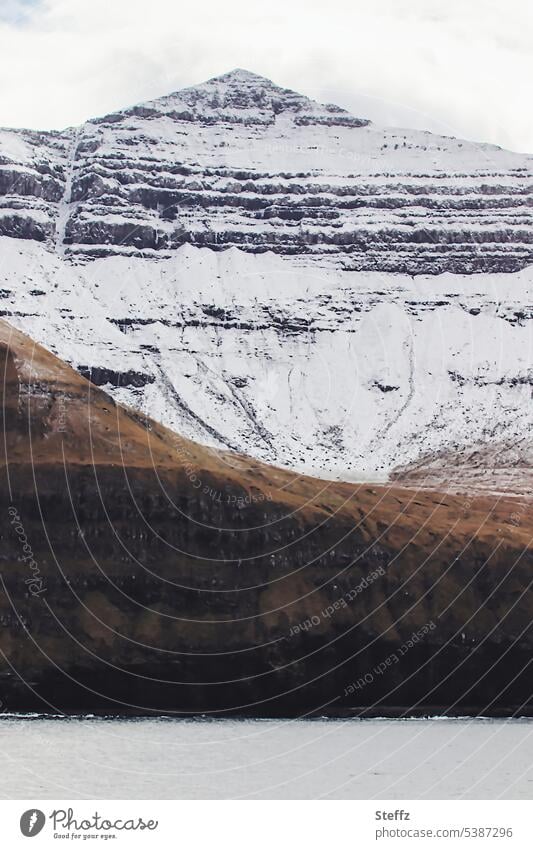 Faroe island with a snowy peak färöer Faroe Islands Sheep Islands rocky cliff rock island snow-covered residual snow Snow Atlantic Ocean Steep Snow layers