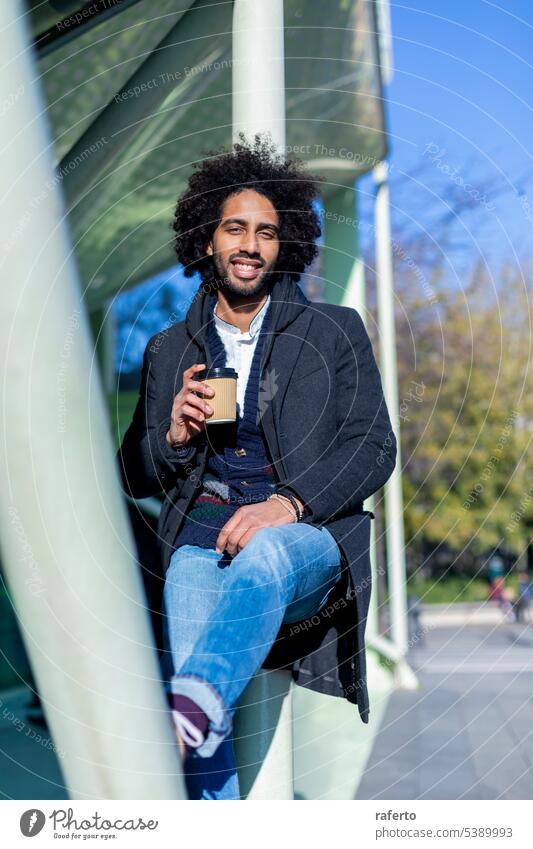 Handsome modern african american man with beard smiling positive standing at the street drinking a take away cup of coffee 1 Black Casual Clothing City Life