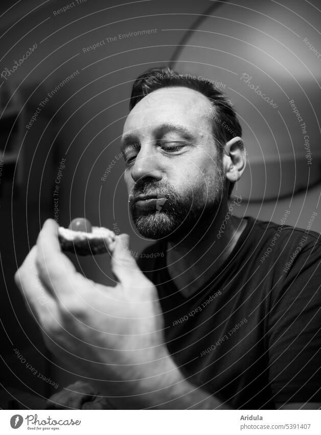 Man sitting at table eating a bread with tomato b/w Eating Face Chew mouthful Mouth Nutrition Human being portrait Delicious potrait Looking room Table Light