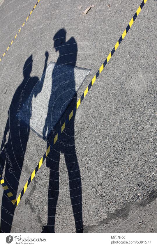 SHADOW BOXES Shadow shadow boxing Silhouette Shadow play Asphalt Street barrier tape flutterband signal strip label mark cordon black-yellow waiting area