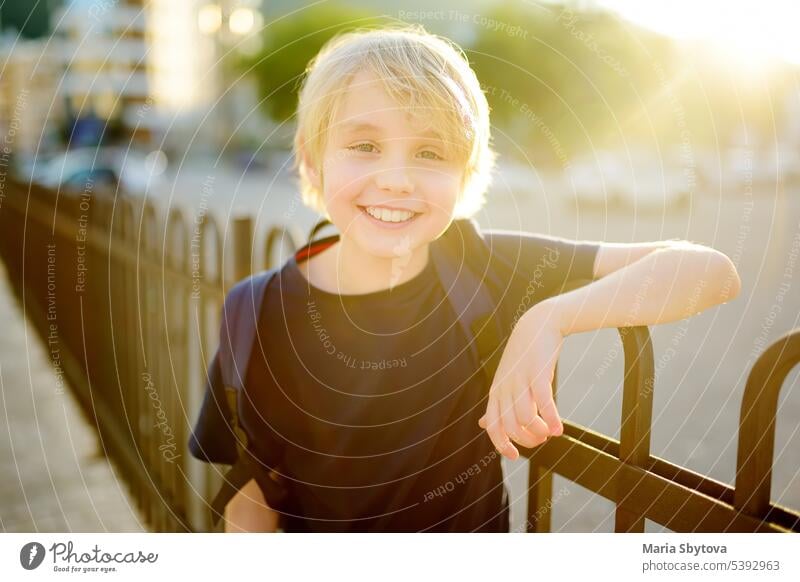 Portrait of cute preteen boy in the city at sunset. Happy child is going to school. kids portrait back to school street positive student backpack caucasian