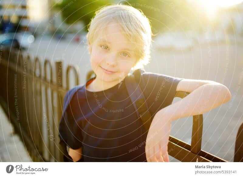 Portrait of cute smiling preteen boy in the city at sunset. Happy child is going to school. kids portrait back to school street positive student backpack