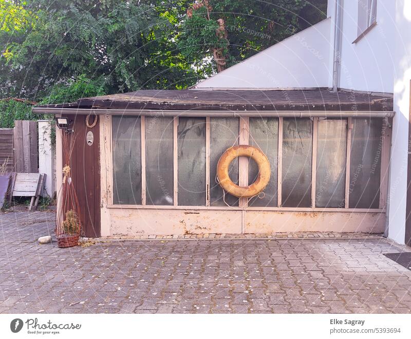 Lifebelt on old garden glass arbor Gardenhouse Deserted Colour photo Day Hut Copy Space bottom Wood Old Exterior shot door Window Sunlight Wall (building)