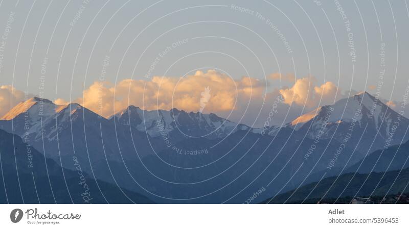 Snow-capped mountains of Trans-Ili Alatau illuminated by the morning sun during sunrise in the morning dawn cloud snow sky hill horizon dusk sunset evening mist