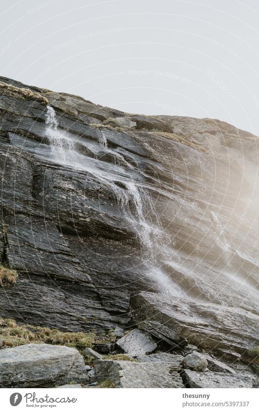 Waterfall from the rock Waterfall landscape Mountain mountains Slope Rock Sunlight Sunbeam Sunbathing Haze steamy Gray