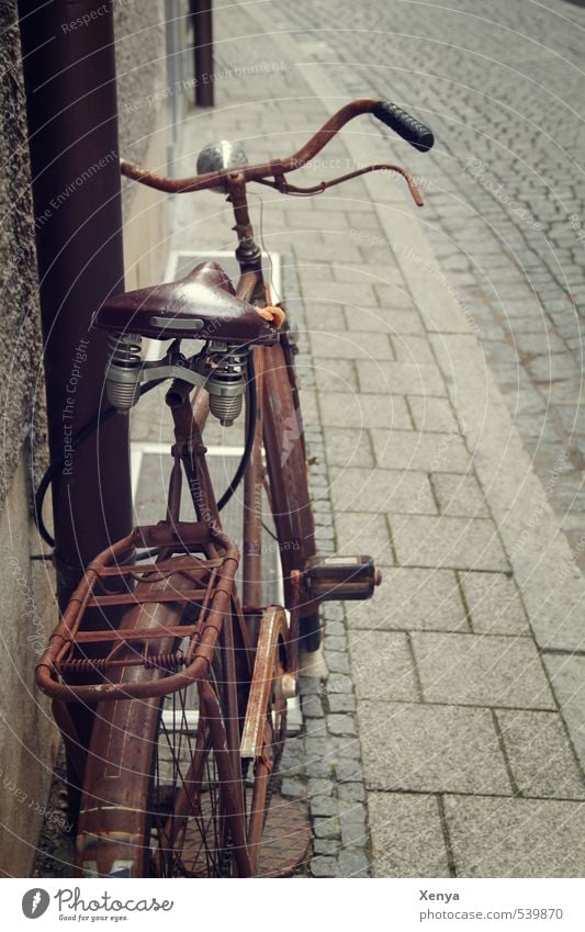 Wheel rust Bicycle Metal Old Retro Town Brown Romance Modest Refrain Rust Cobblestones Memory Nostalgia Ajar Break Bicycle saddle Subdued colour Exterior shot