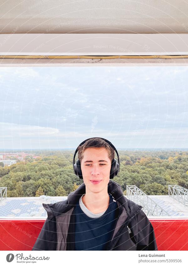 Teen in Ferris wheel with headphones teenager Headphones Music Listen to music Joy Technology youthful Lifestyle Boy (child) Smiling Brunette