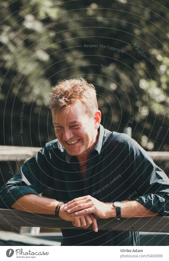 Joie de vivre| man leaning on railing and looking down laughing Expression fun portrait Cheerful Happy Happiness sympathetic Brilliant Laughter Smiling human