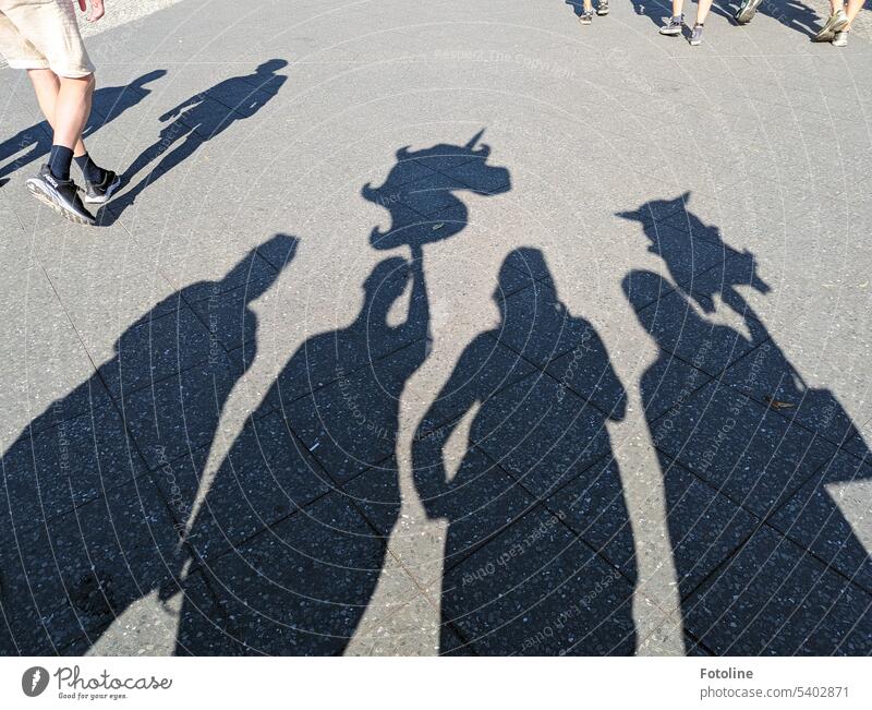 Party shadows - The shadows of 4 party mice. 2 are holding a balloon. A unicorn and a Pikachu. Shadow people Silhouette Pedestrian Walking Street person