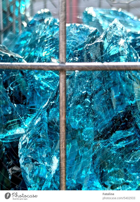 Metal struts hold lumps of glass that look like ice. Blue and clear. Glass Light ice blue light blue Bright Glass nugget Glass blocks Sunlight metal struts