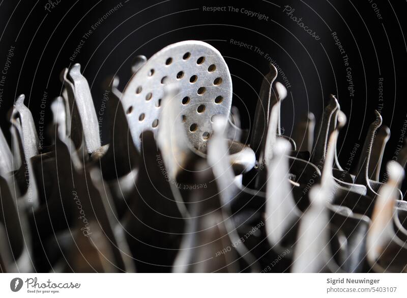 A silver skimmer head towers over a human-like crowd of metal forms that seem to surround or carry him. Perhaps he represents a speech to an audience that cheers him. Interpretations are numerous.