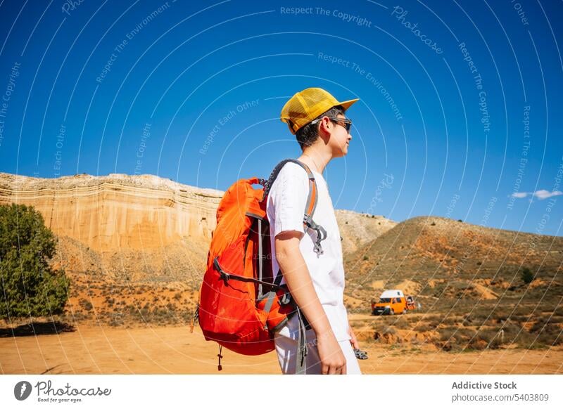 Teenage boy in sunglasses with backpack in desert traveler tourist adventure kid canyon vacation mountain hill cliff rojo teruel nature van journey edge