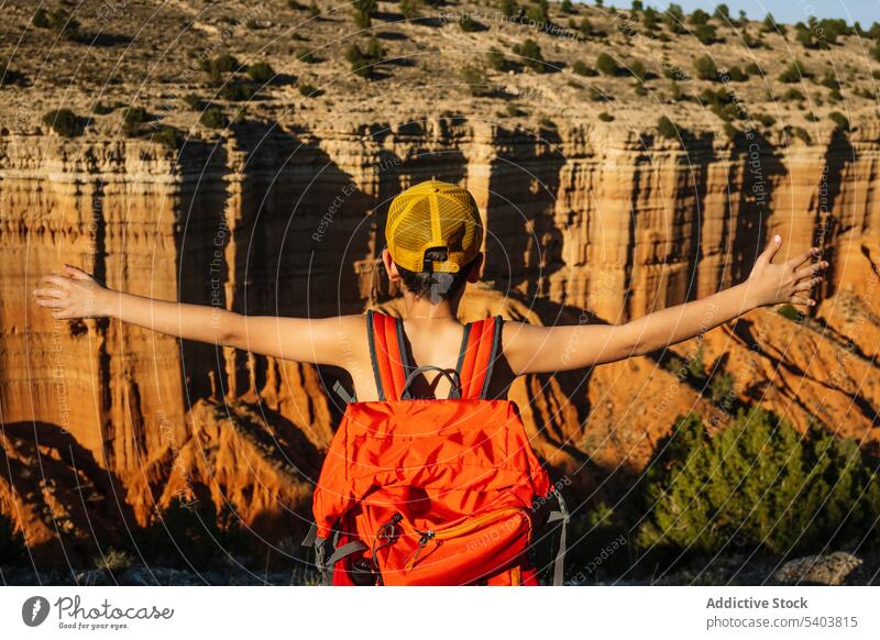 Unrecognizable traveler with backpack above majestic mountains boy anonymous shirtless freedom canyon cliff shadow male vacation casual rojo teruel adventure