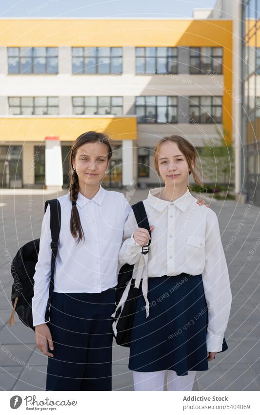 Happy young school girls standing in compound schoolgirl student teenage classmate uniform adolescent smile friend pupil positive happy together friendly