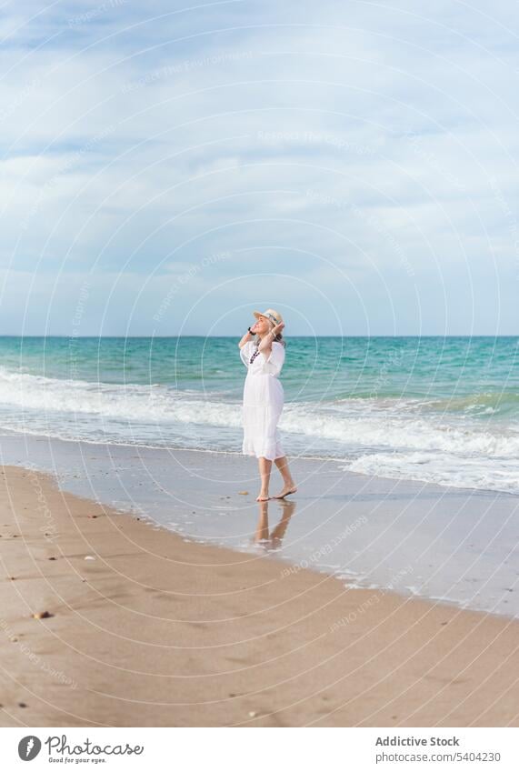 Happy woman walking on sandy beach happy freedom enjoy vacation summer sea nature elderly senior pensioner aged shore wave water seashore coast female ocean