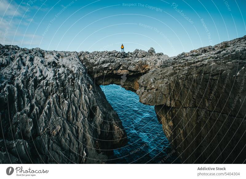 Male hiker on rocky cliff near ocean man traveler sea nature cantabria picturesque male scenery observe vacation wanderlust person spain scenic journey tourism