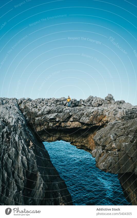 Male hiker on rocky cliff near ocean man traveler sea nature cantabria picturesque male scenery observe vacation wanderlust person spain scenic journey tourism