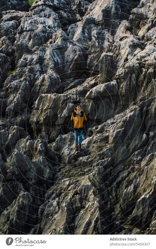 Male hiker standing on rocky mountain slope man traveler adventure cliff explore highland spain nature male summer vacation landscape wanderlust distant