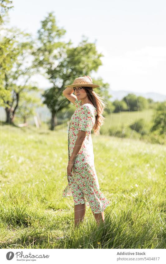 Woman in summer dress walking in countryside woman nature lawn grass green rest field style relax straw hat female meadow idyllic harmony rural feminine