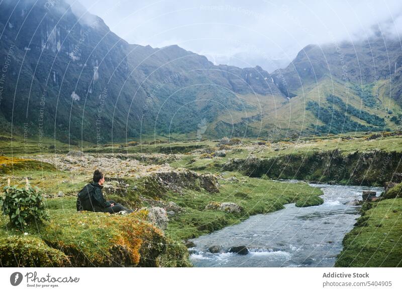 Traveling woman sitting on stone by river mountain admire volcano valley traveler nature highland tourist backpack spectacular altar ecuador picturesque