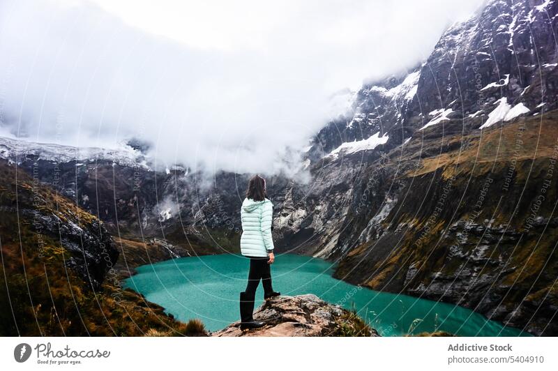 Female traveler admiring cloudy mountain and river woman admire lake volcano nature cliff landscape tourist altar ecuador female adventure vacation rock