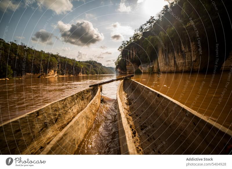 Boats floating on rippling river water in daytime transport boat tree hill wooden forest blue sky nature countryside cloudy travel bow green flow mountain