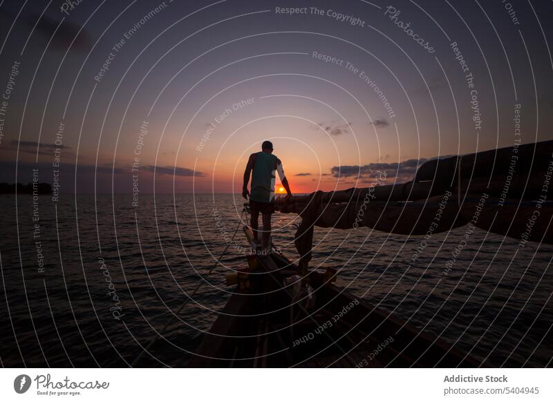 Silhouette of man on boat in sea at sunset yacht silhouette admire nature edge sky water ocean sundown explore enjoy coast travel traveler picturesque male