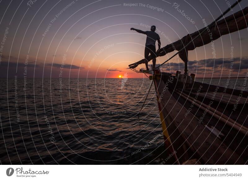 Silhouette of man on boat in sea at sunset yacht silhouette admire nature edge sky water ocean sundown explore enjoy coast travel traveler picturesque male