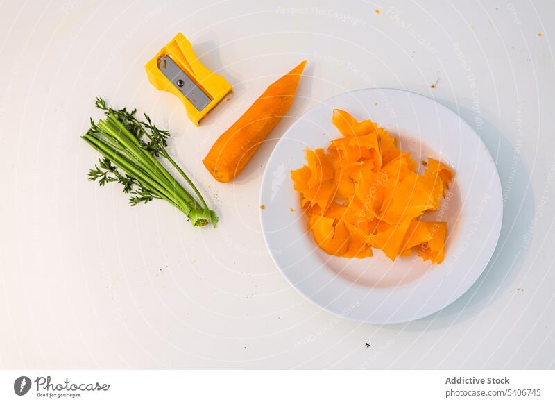 Plate with fresh peeled carrot and sharpener on table vegetable slice stem cut plate vegetarian food stalk diet organic green vitamin vegan natural nutrition