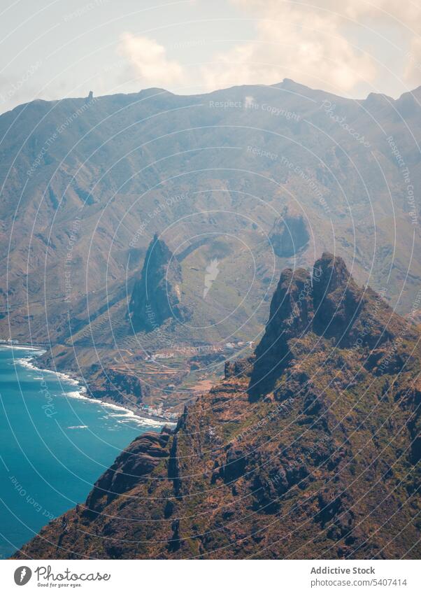 Amazing view of mountains with dry terrain and sharp peaks rocky ridge formation nature picturesque rough landscape blue sky sea range slope highland