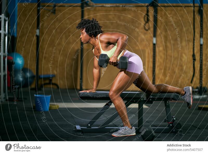 Black athlete exercising on bench with dumbbell sportswoman exercise weightlifting heavy training workout fitness mature afro african american black ethnic