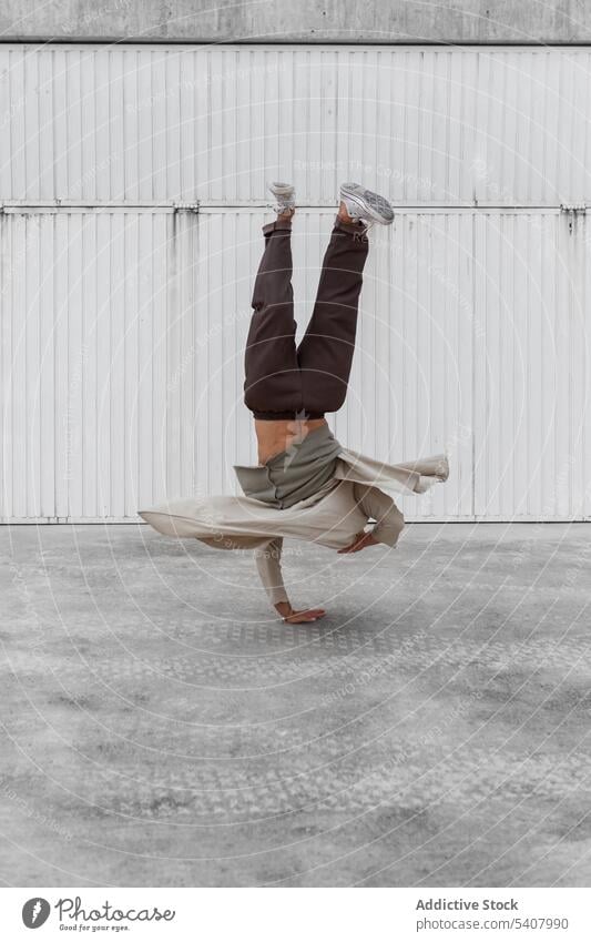 Male break dancer performing on street man hip hop hand hops urban freestyle balance male city move upside down action choreography talent modern motion energy