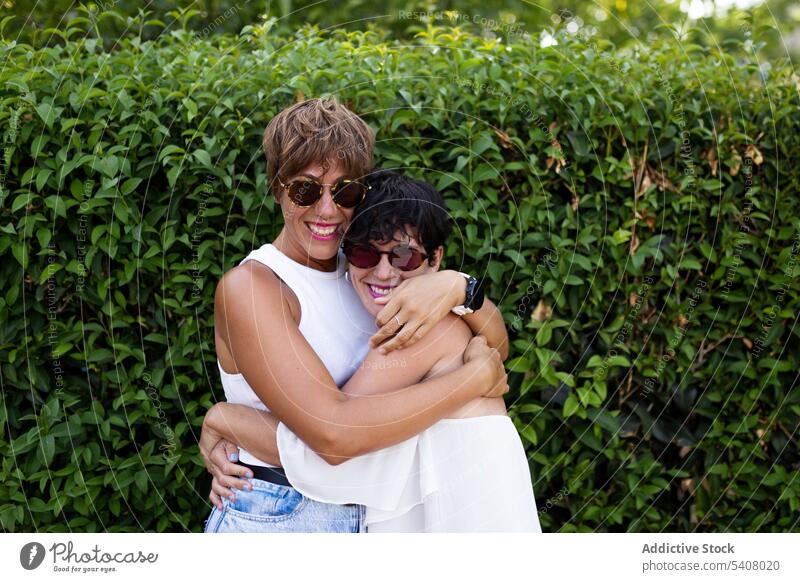 Candid female friends hugging in park best friend women friendship sincere smile adult embrace green friendly relationship glad summer joy optimist weekend