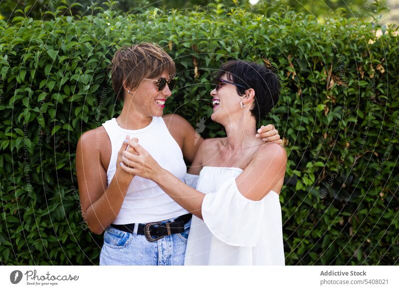 Candid female friends hugging in park best friend women friendship sincere smile adult embrace green friendly relationship glad summer joy optimist weekend