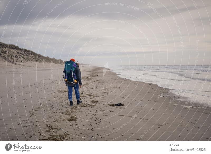 Woman with child in backpack walking on autumn beach Beach Child Childhood memory stroll Beach dune Water Autumnal Ocean Waves Sky wide Trip Vacation & Travel