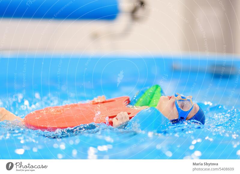 Little boy with glasses and inflatable armbands in swimming pool. learn child kid sport section education lesson indoors active healthy activity caucasian class