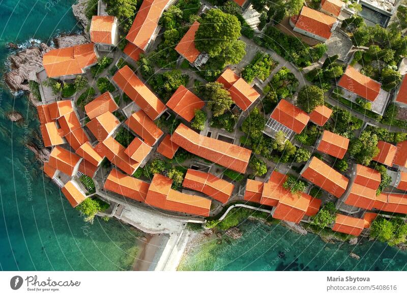 Amazing sunset aerial top drone view of Sveti Stefan hotel island with historical town. Top down view of picturesque little island in Adriatic Sea located in Montenegro.