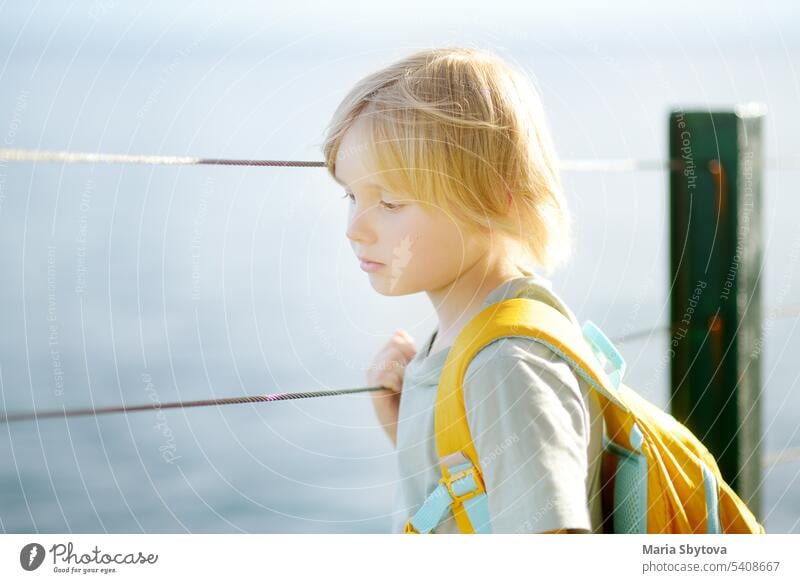 Close up portrait of upset child with satchel. Sad boy don't want to go to school. Kid's fear. Problems of children with learning or classmates. Help of psychologist for schoolchildren.