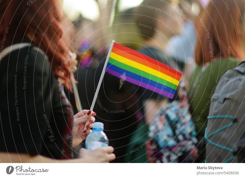 Activist woman holding rainbow flag and banner on the march on the city street during the Lgbt Pride Parade. Fighting for equality os sexual minorities. lgbtq