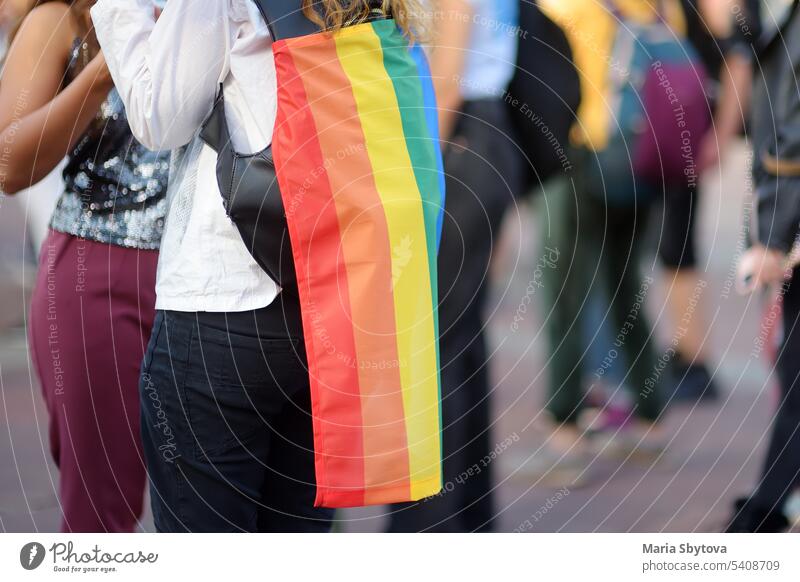 Rear view of people column during the Pride Parade. Crowd on the city street with lgbt rainbow flag. lgbtq pride lesbian couple embrace parade queer protest