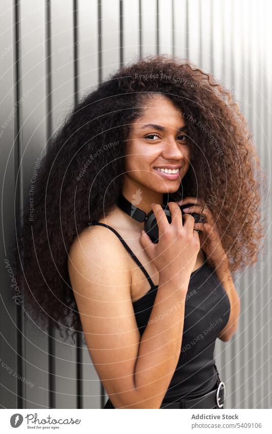 Delighted black woman enjoying music in headphones listen street song cheerful curly hair afro female ethnic african american hairstyle hairdo positive young