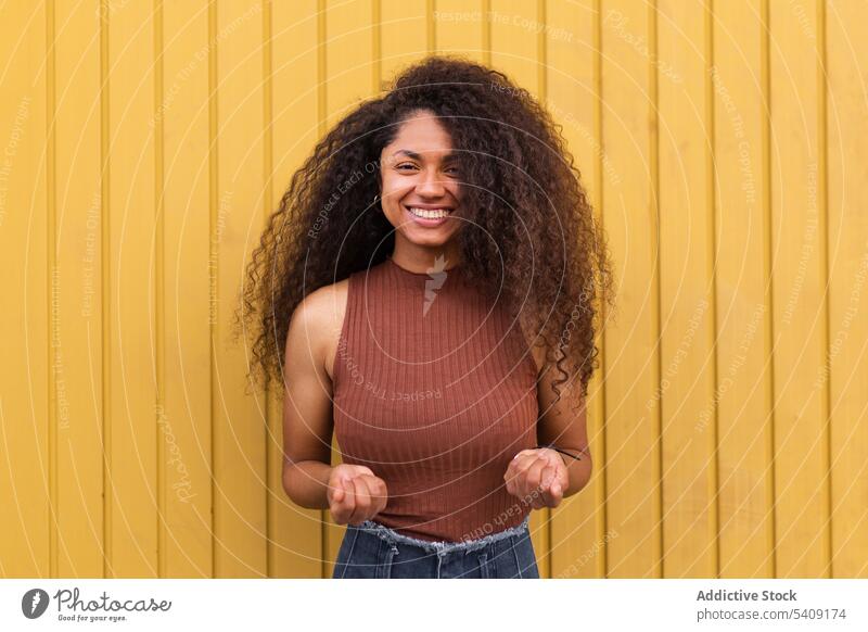 Black woman scattering confetti on street toss having fun cheerful delight festive celebrate event female ethnic black african american city happy joy smile