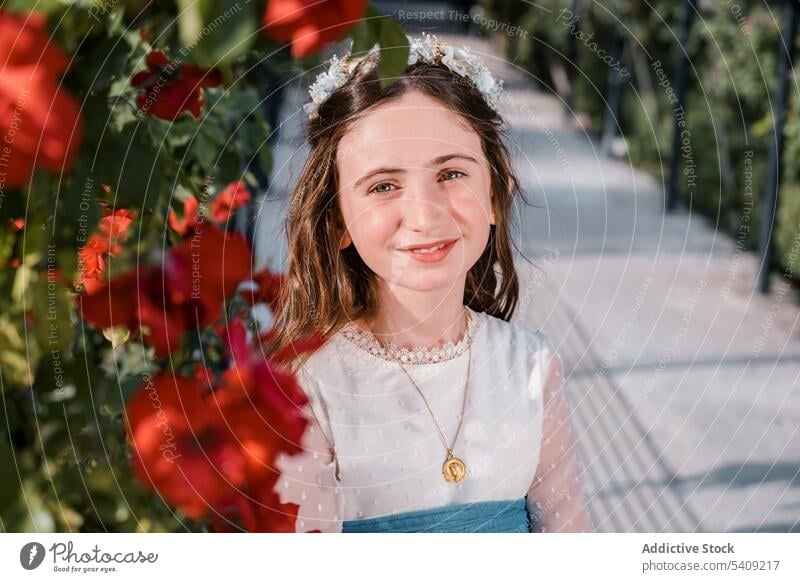 Happy charming girl in floral wreath flower happy dress park portrait smile joy glad style nature positive child lifestyle green blossom optimist lady red