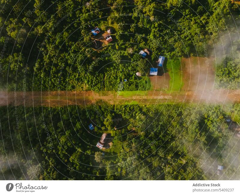 Drone view of green tropical forest village hill countryside rainforest house road landscape tree nature picturesque cottage peaceful slope settlement rural