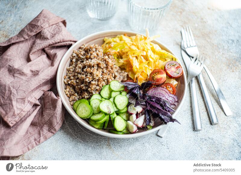 Plate with delicious veggie meal, cutlery and glasses on table vegetarian buckwheat vegetable onion cucumber tomato basil bowl salad herb weight loss healthy