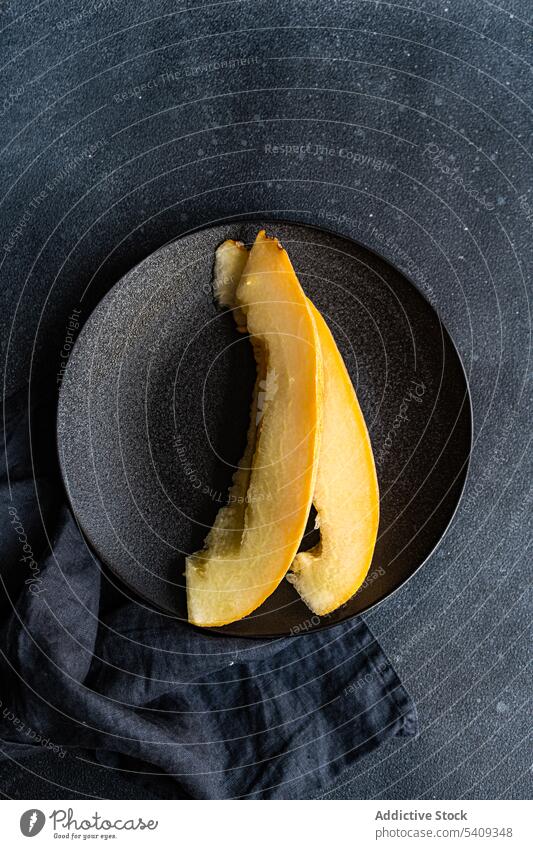 Slices of sweet ripped melon served on concrete black table slice fruit piece plate delicious rustic summer vitamin healthy season appetizing ripe tasty dessert