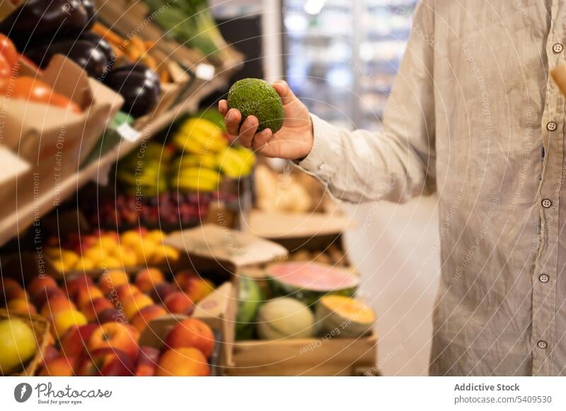 Crop man choosing fruit in fruit shop grocery store choose person supermarket food purchase product shopper customer various shelf choice ripe casual buy retail